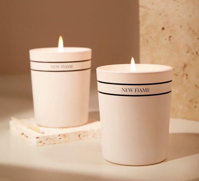 a couple of white candles sitting on top of a table