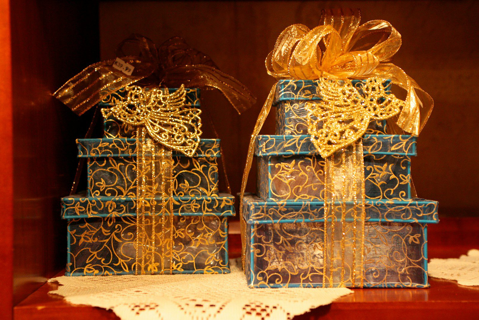 Two stacks of ornate gift boxes with gold ribbon